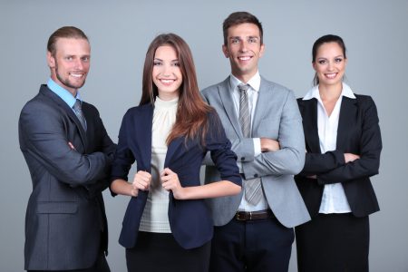Business team standing in row on grey background